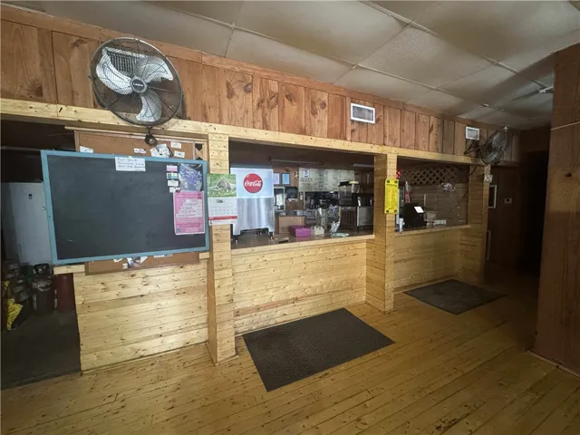 This rustic commercial space features exposed wooden paneling and durable flooring, offering a warm and inviting atmosphere.