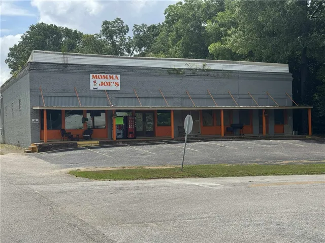 This commercial property features a brick exterior and a paved parking lot.