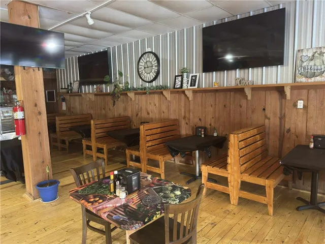 This dining area features rich wood paneling, wood flooring, and ample seating for a cozy ambiance.