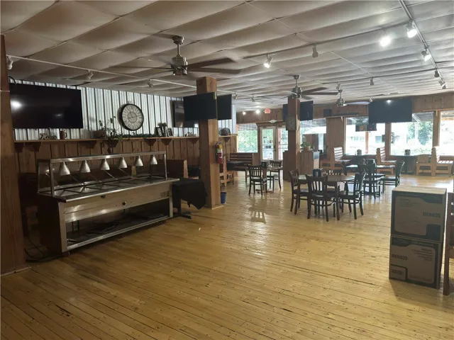 This spacious commercial interior features warm wood flooring and ample natural light, creating an inviting atmosphere.
