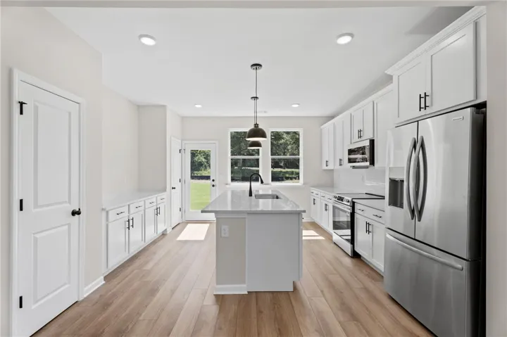 Gleaming white cabinetry and a spacious central island define this well-appointed culinary space.