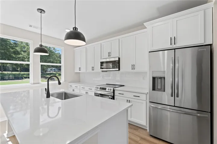 Modern kitchen with crisp white cabinetry and a generous island, perfect for culinary endeavors.
