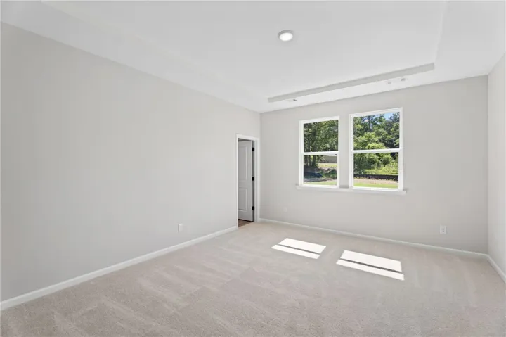 Sun-filled room with large windows and plush carpet.