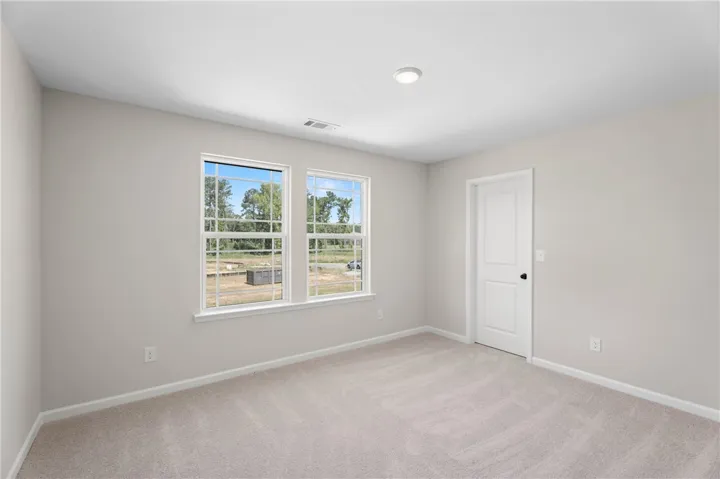 A quiet, carpeted room bathed in natural light, offering views of the surrounding landscape.