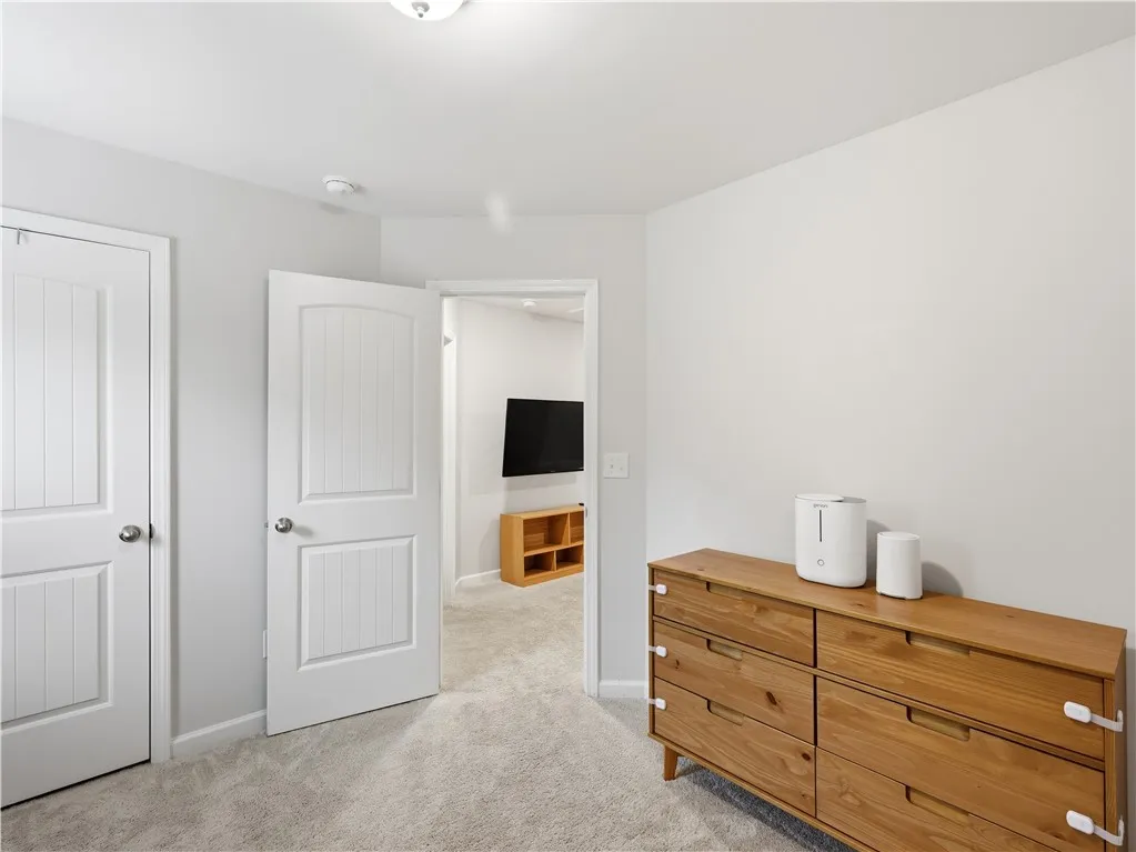 This spacious bedroom offers comfortable carpeting and convenient access to an adjoining living area.