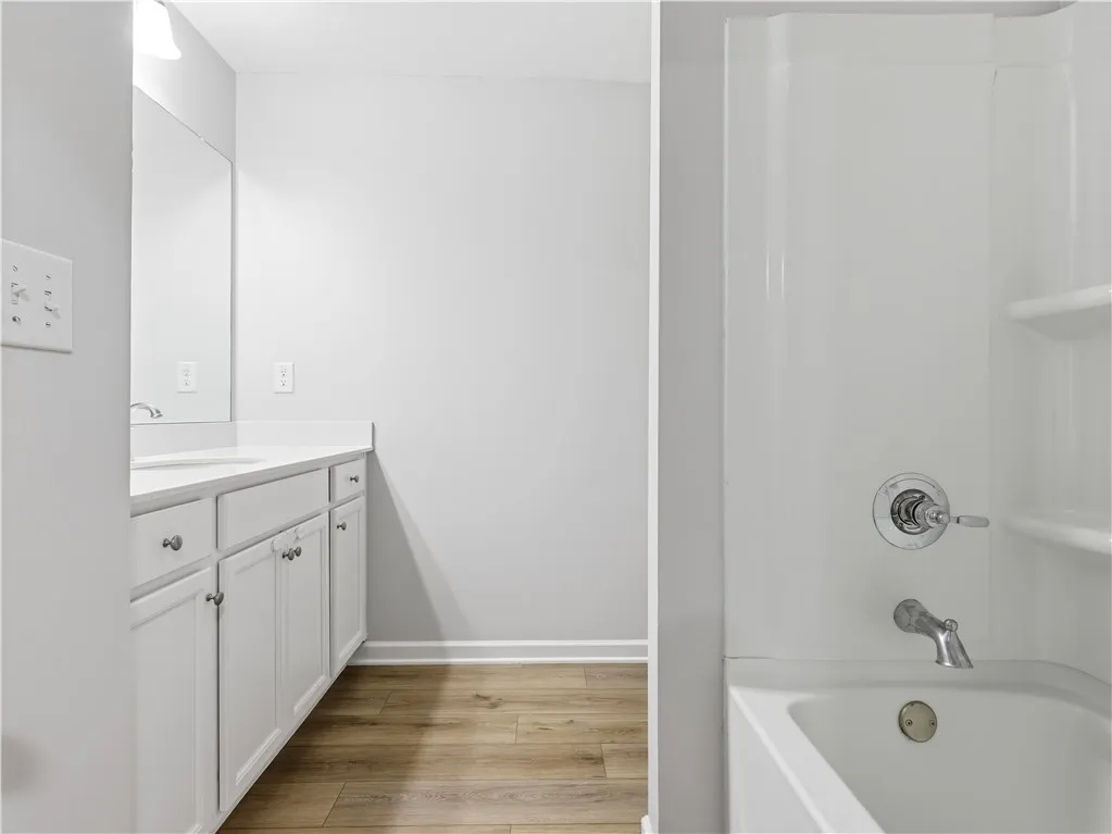 This bathroom features a sleek vanity and a classic tub-shower combination.
