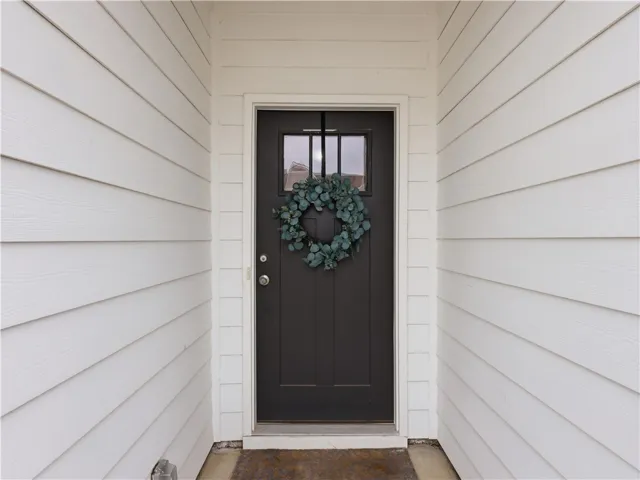 Welcome guests through a classic front door, framed by clean, inviting siding.