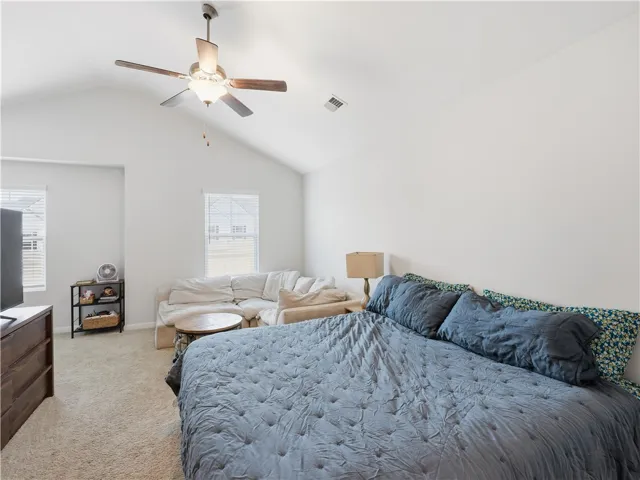 Bright and airy bedroom with vaulted ceilings and large windows, creating a spacious and inviting retreat.