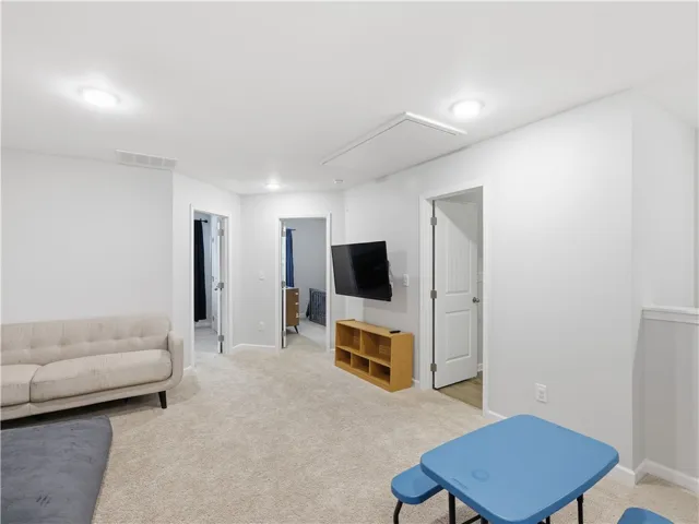 This versatile bonus room features soft carpeting and ample lighting for comfortable living.