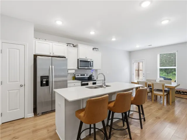 This bright kitchen features an island, ample counter space, and durable flooring, perfect for entertaining.