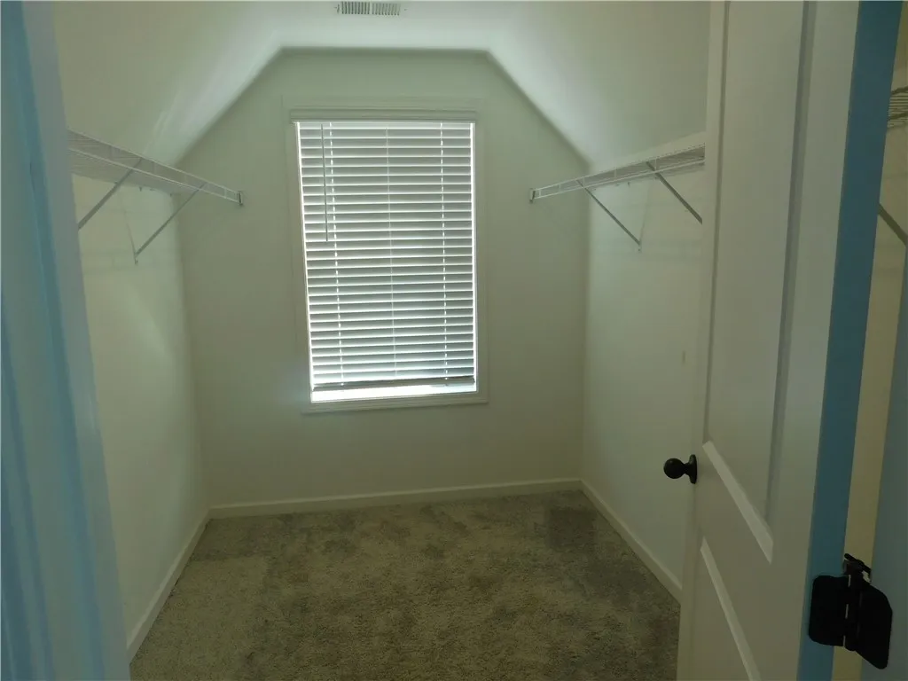This cozy closet features practical shelving and abundant natural light.