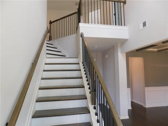 This grand staircase features elegant wood and iron railings, adding architectural interest to the home's interior.