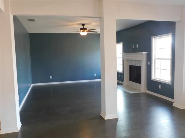 This expansive living area features rich wood flooring and a classic fireplace.