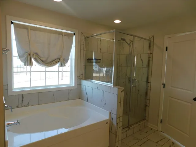 Relax and refresh in this tranquil bathroom, offering both a soaking tub and a sleek shower.