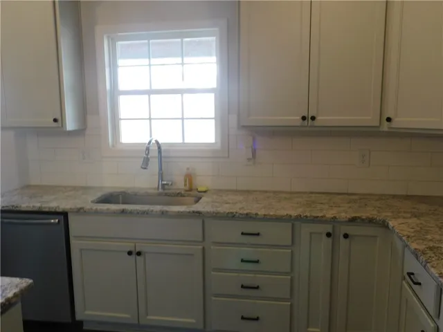 This kitchen features elegant cabinetry, a convenient sink, and ample counter space.