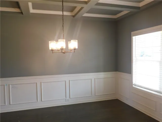 This elegant space features a coffered ceiling and paneling, ready for your personal touch.