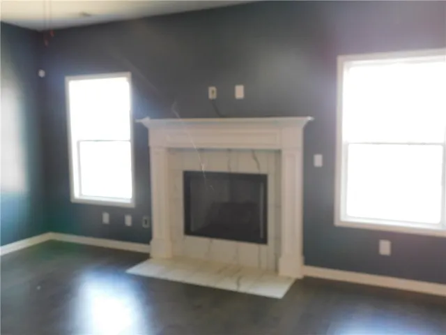 This inviting living space features rich flooring and a classically designed fireplace.