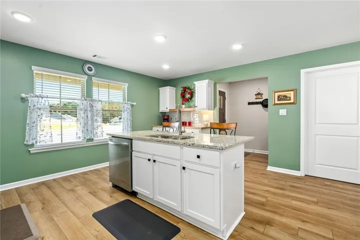 This bright kitchen features an island, ample counter space, and durable flooring, perfect for daily living.