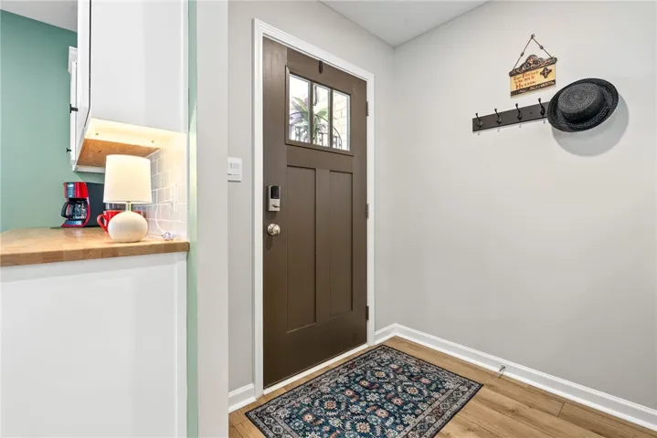 Step into a welcoming entry featuring rich wood flooring and a classic door.