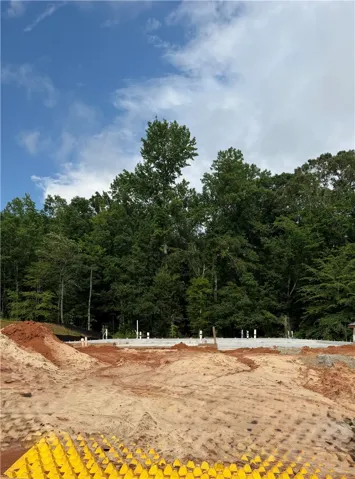 A new construction site with a freshly poured foundation, ready for a dream home amid lush natural surroundings.
