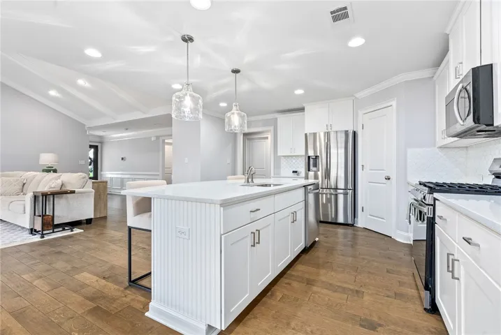 Serving as the perfect bridge between the kitchen and the spacious living area, the dual-sided island offers practical workspace and a natural hub for entertaining.