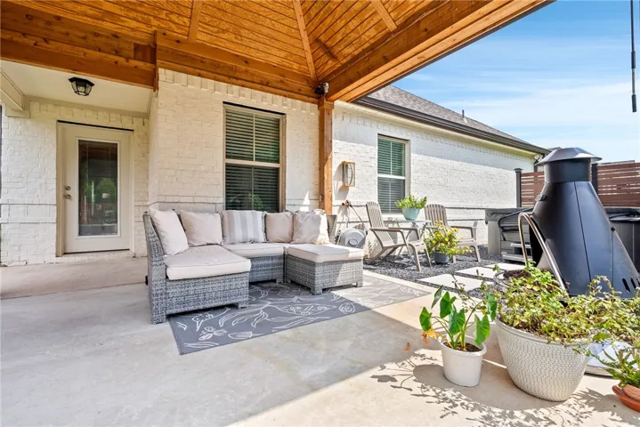 Newly crafted by Creative Habitats, this stunning cedar covered porch added tons of living space to the home. The new concrete pad accommodates seating, a grill, and a fireplace, while stylish rock-bed planters, a privacy fence, and natural landscaping create a secluded retreat. The porch offers gutters, a fan, and solar lights to enhance its functionality.