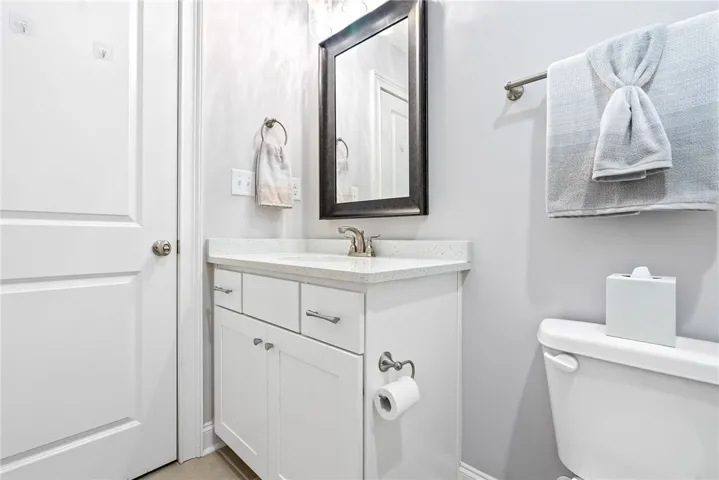 Quartz countertops, a tub/shower combination, and generous space make this bathroom both functional and inviting for family or guests.