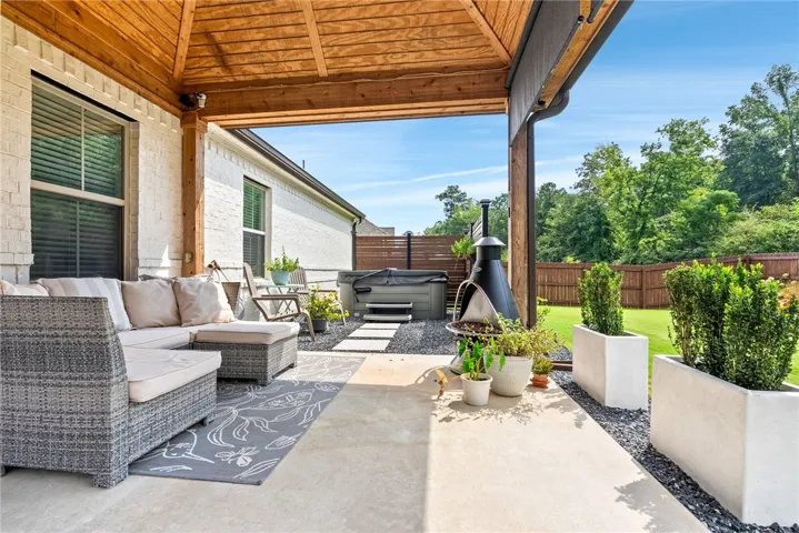 Just beyond the covered porch is a hot tub located behind a tasteful screen for additional privacy.