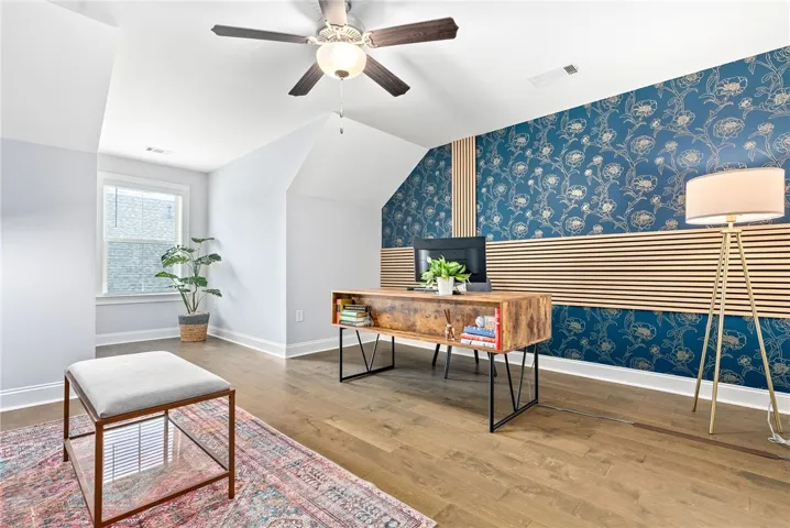 Bonus room/bedroom 4 combines generous space with sophisticated design, highlighted by wallpaper and a built-in wall system. Versatile enough for use as a bedroom, office, or rec room, it also offers an adjoining powder bath and extra closet space for added functionality.