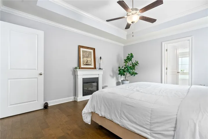 The tray ceiling adds a distinctive architectural touch, elevating the style of the primary bedroom.