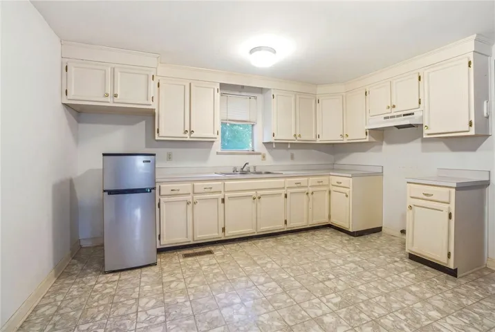 Spacious kitchen in studio apartment above garage.