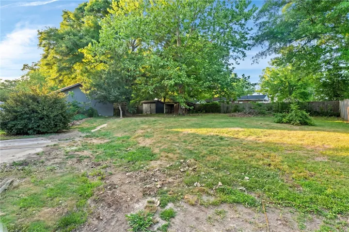 This spacious yard offers ample outdoor living potential, surrounded by lush trees and natural charm.