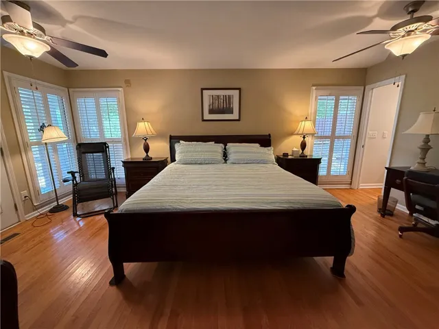 This spacious bedroom offers ample light and comfort with beautiful hardwood flooring.
