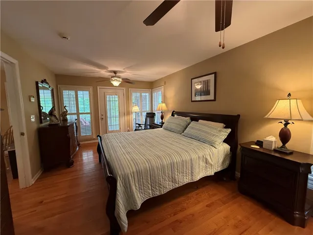 This inviting bedroom offers hardwood floors, ample natural light, and direct outdoor access.