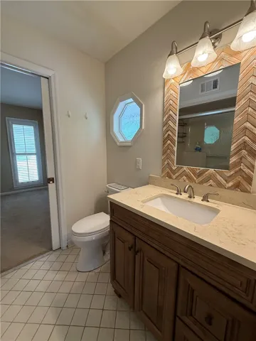 This bright bathroom features a vanity with ample counter space and a modern toilet.