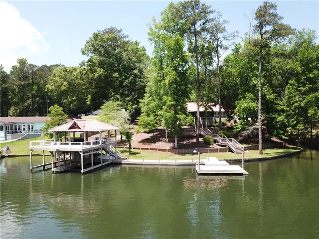 This tranquil waterfront property features a private dock and a charming boathouse amidst lush surroundings.