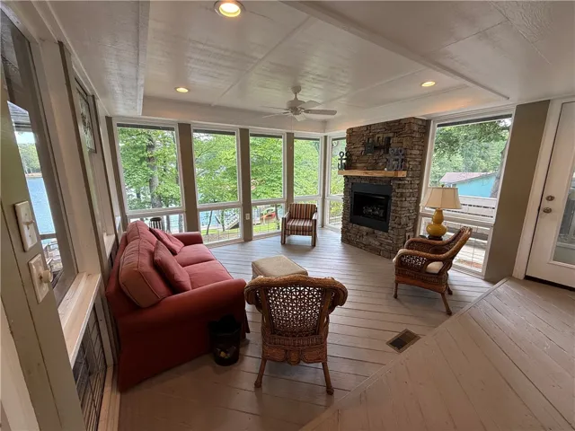 This bright sunroom offers expansive lake views and a cozy fireplace, perfect for serene relaxation.