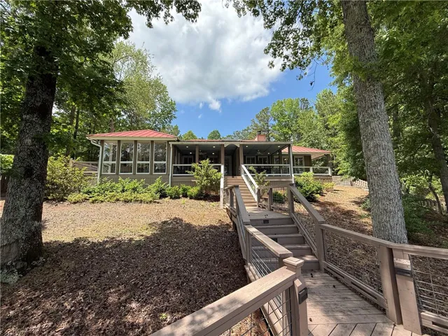 This charming retreat is nestled among mature trees, offering serene views and a private walkway.