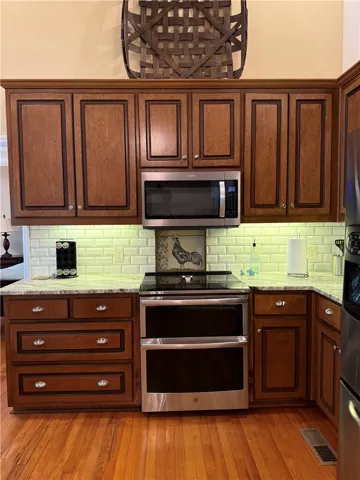 This warm kitchen features rich wood cabinetry and essential appliances for everyday culinary endeavors.