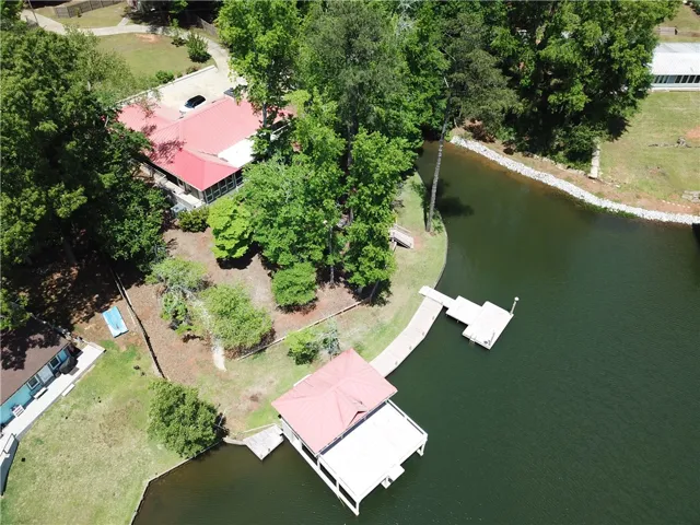 This serene waterfront property features a private dock and mature trees, perfect for tranquil living.