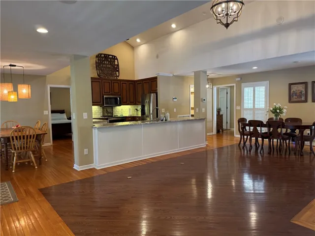 This expansive open-concept living space boasts gleaming hardwood floors and abundant natural light.