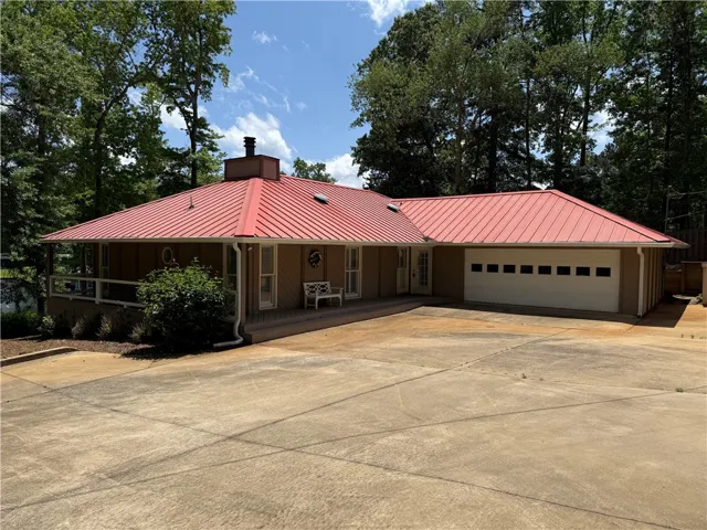This residence features a vibrant red roof and an inviting porch, perfect for outdoor enjoyment.