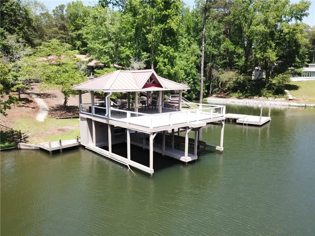 This serene waterfront property offers a private dock with covered seating, perfect for lakeside enjoyment.