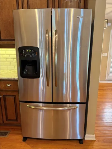 This kitchen showcases a modern stainless steel refrigerator.