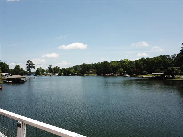 Enjoy tranquil lake views with lush greenery under a clear sky.