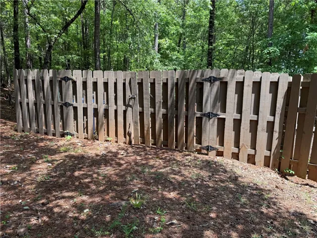 Secure your outdoor space with this sturdy wooden privacy fence, perfect for peace of mind.