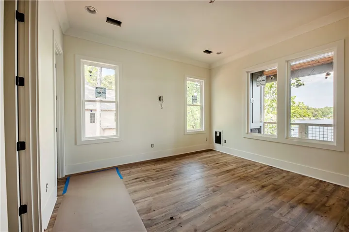 This bright room features beautiful flooring and expansive windows, offering tranquil water views.