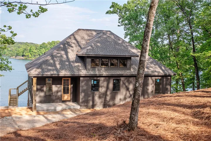 This newly constructed lakefront residence features a classic shingle roof and access to the water.