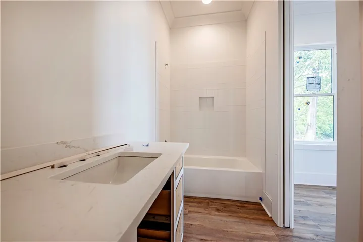 This bathroom features a contemporary vanity with a sleek countertop and a clean, inviting bathtub.