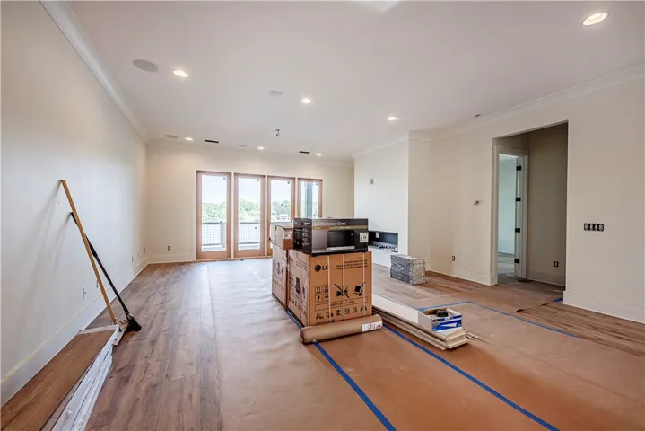 This bright, airy living area offers elegant hardwood flooring and a view of the outside.
